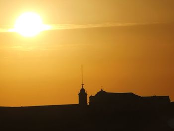 Silhouette of building against sky during sunset