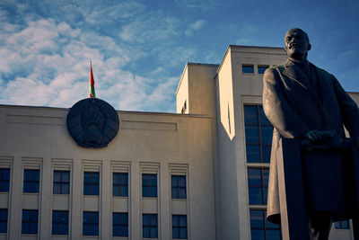 Low angle view of statue against building against sky