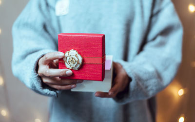 Midsection of woman holding red while standing in box