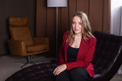 A nice girl psychologist is waiting for a client on the couch for a consultation