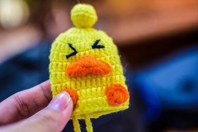 Close-up of hand holding yellow toy
