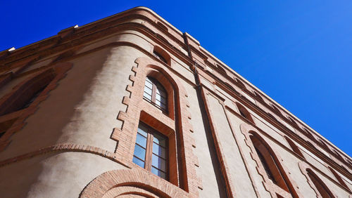 Low angle view of building against clear blue sky