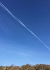 Scenic view of vapor trail against clear blue sky