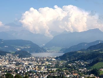 Aerial view of townscape and mountains against sky