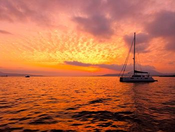 Sailboat in sea against sky during sunset