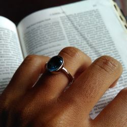 Cropped hand wearing ring on book