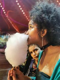 Woman with afro eating candyfloss at the circus