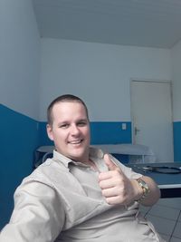 Portrait of smiling young man sitting at home