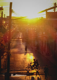 High angle view of people on street by buildings during sunset