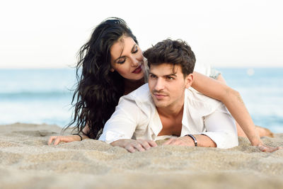 Couple lying on sand at beach