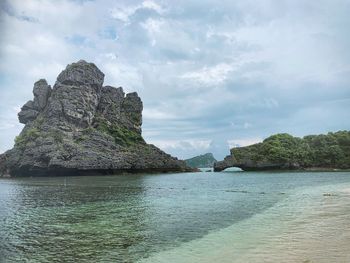 Rock formation in sea against sky