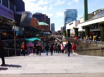 People walking on street amidst buildings in city