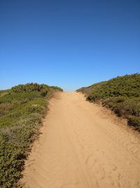 Scenic view of desert against clear blue sky