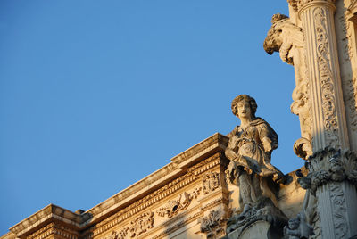 Low angle view of statue against blue sky