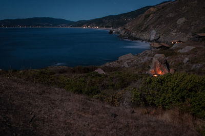 Scenic view of sea and mountains against sky campfire