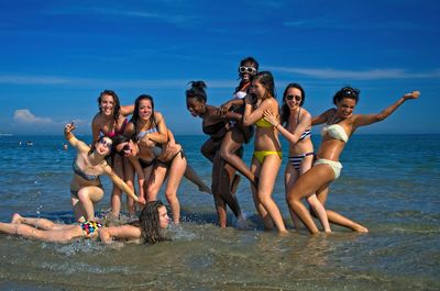 Group of people at beach against sky