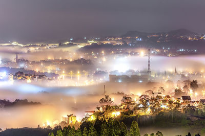 High angle view of illuminated cityscape against sky at night