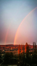 Rainbow over cityscape against sky