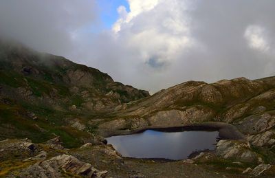 Scenic view of river by mountains against sky