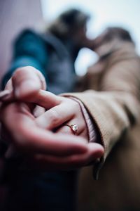 Low angle view of couple holding hands while kissing each other