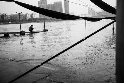 Man on bridge over river in city