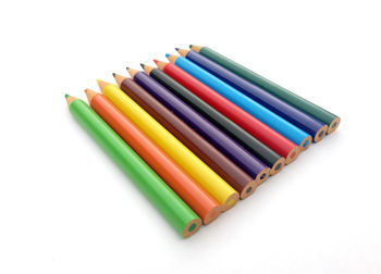 High angle view of colored pencils against white background