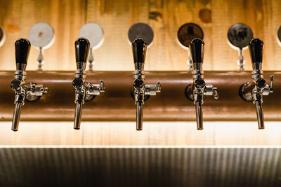 Close-up of beer taps at bar counter