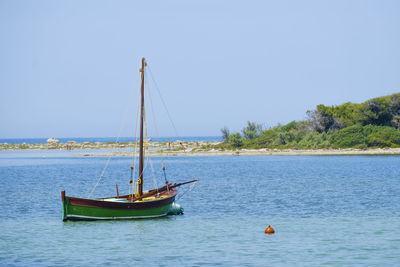 Boat sailing in sea against clear sky