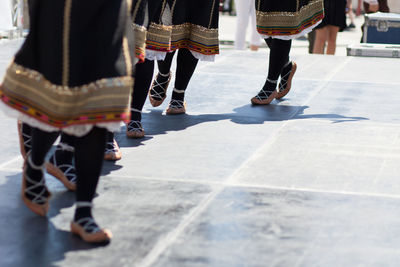 Low section of female dancers on walkway during traditional festival