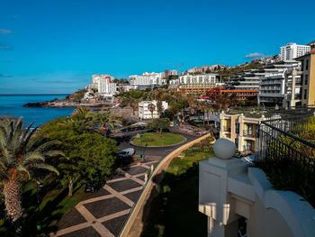 High angle view of swimming pool by buildings against sky