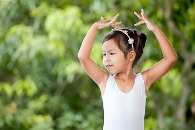 Cute girl dancing against plants