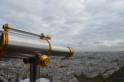 Close-up of coin-operated binoculars and cityscape