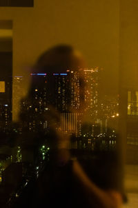 Illuminated cityscape against sky at night