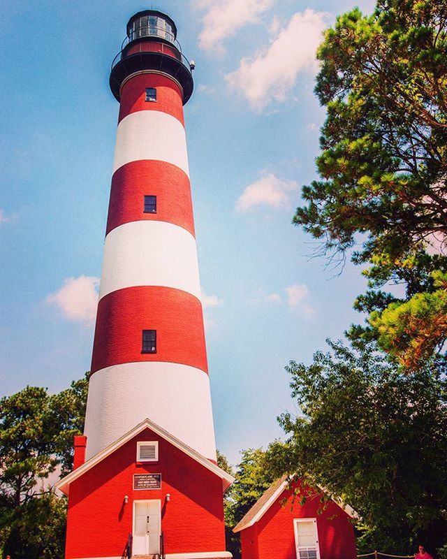 architecture, red, building exterior, built structure, lighthouse, sky, tower, protection, guidance, safety, low angle view, direction, security, tree, day, no people, outdoors, cloud - sky, cloud, blue