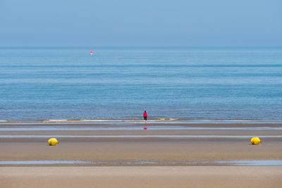 One woman in the distance enjoying an empty beach and the view across the sea at bray-dunes, france