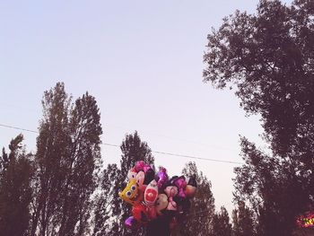 Low angle view of multi colored umbrellas hanging against sky