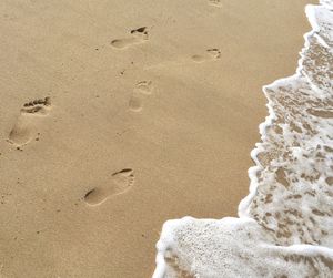 High angle view of footprints on sand at beach
