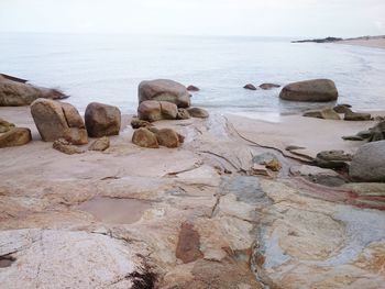 Rocks on beach against sky