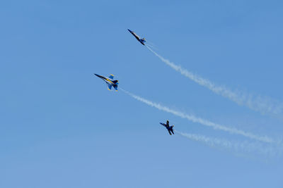 Low angle view of airshow flying against sky