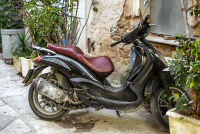 Close-up of abandoned motor scooter against wall