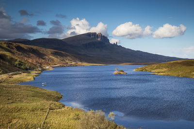 Scenic view of lake by mountain against sky