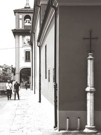 People walking on street in city against sky