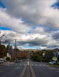 Road by trees against sky