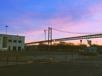 Bridge over city against sky during sunset