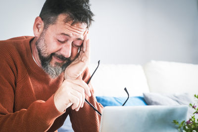 Young man using mobile phone while lying on bed at home