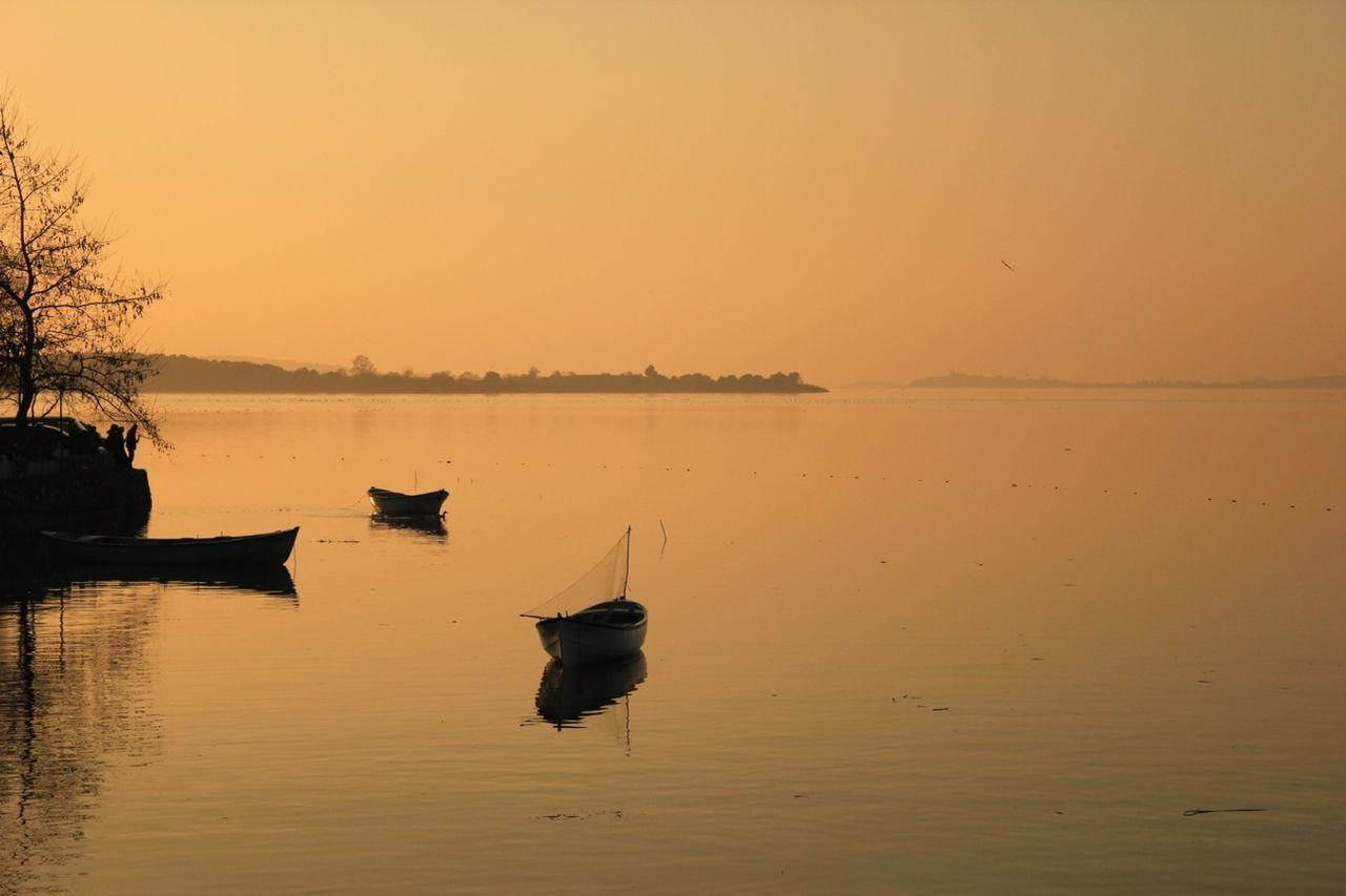 water, nautical vessel, boat, sunset, transportation, mode of transport, moored, tranquil scene, clear sky, tranquility, lake, scenics, beauty in nature, reflection, nature, copy space, waterfront, silhouette, idyllic, orange color