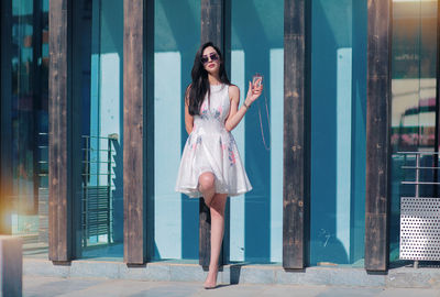 Full length of woman standing against the wall