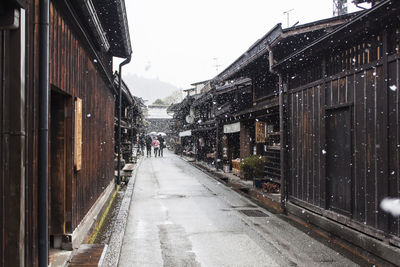 Street amidst buildings in city during winter