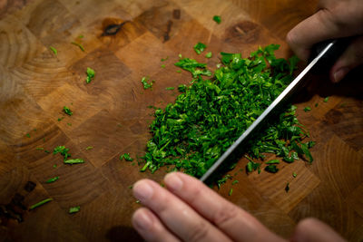 Cropped image of person holding cutting board on table