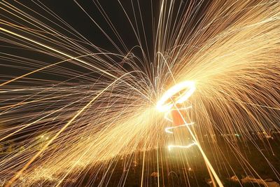 Man spinning wire wool at night